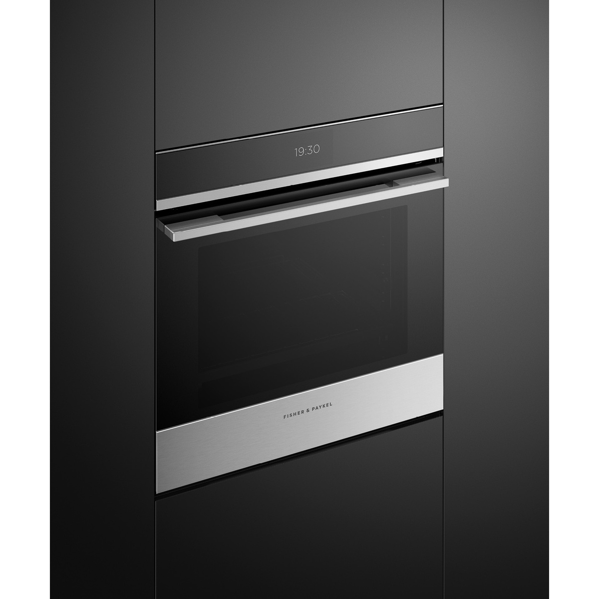 Fisher & Paykel OB24SDPTX1 oven installed in dark contemporary kitchen cabinetry, angled view showing stainless steel handle, black glass door, and time display