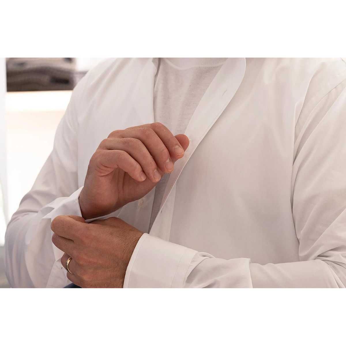 Person holding a lightweight shirt in a laundry room to show refreshed clothing