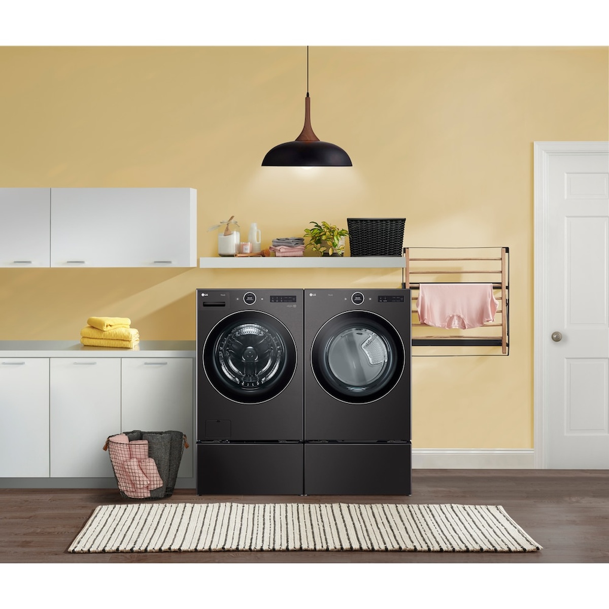Laundry room with an LG front-load washer and dryer installed side by side on matching black pedestals