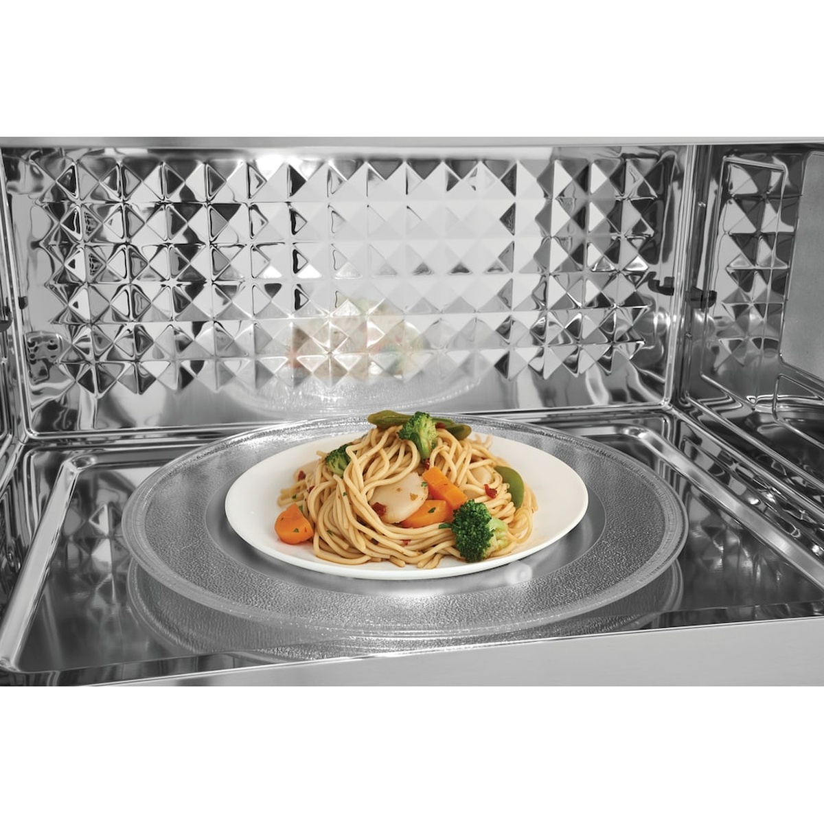 Inside view of the microwave showing a glass turntable with a plate of food