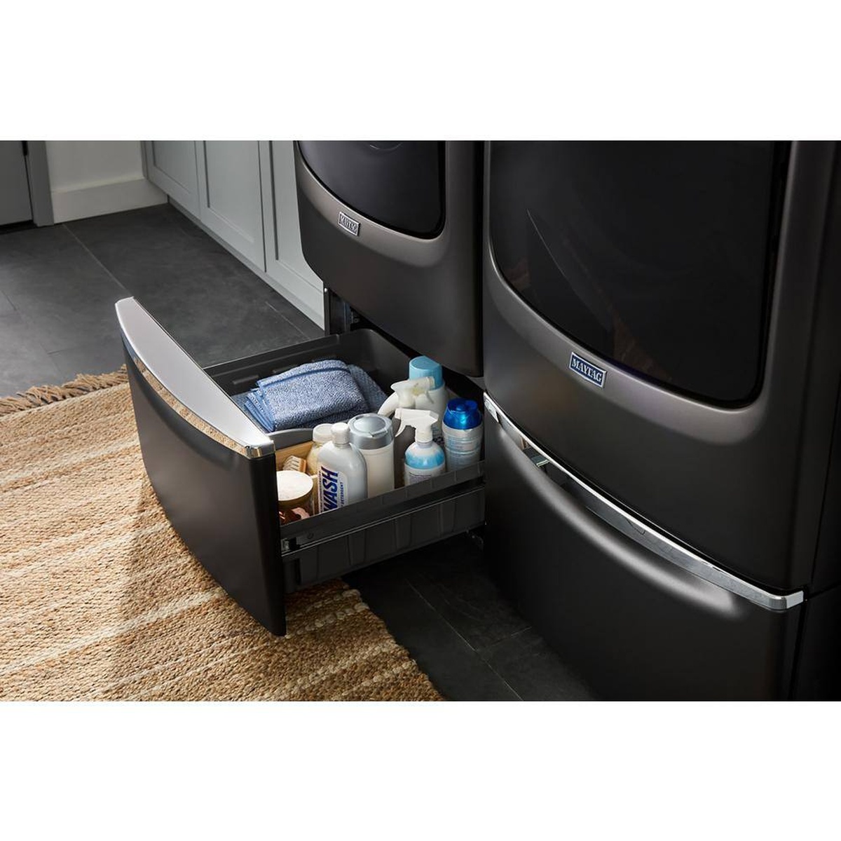 Maytag laundry pedestal drawer pulled open with cleaning supplies stored inside under matching laundry units