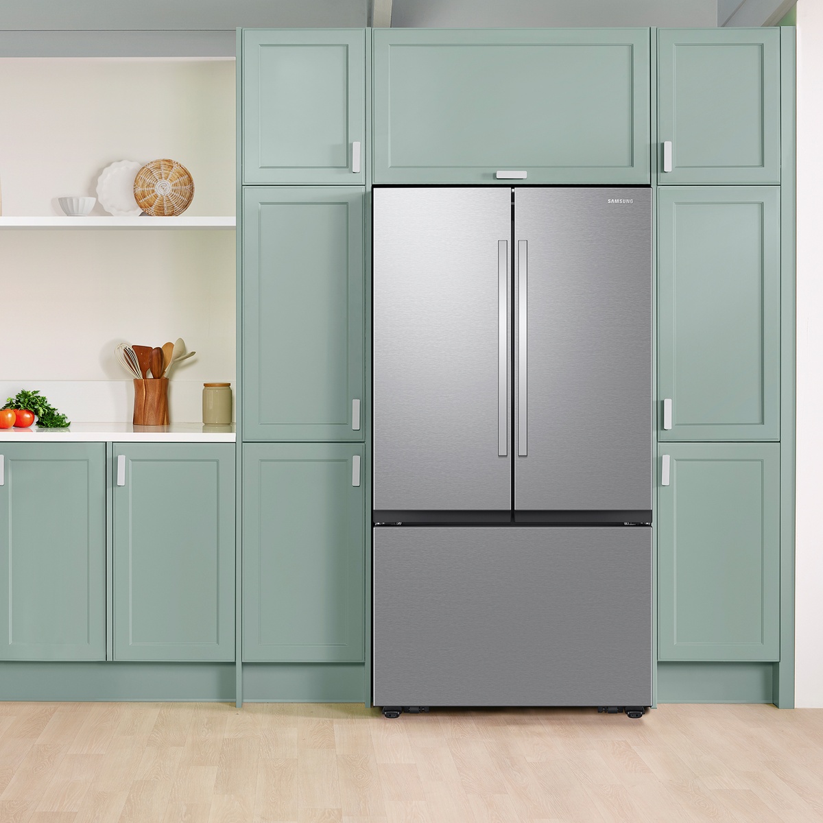 Stainless steel Samsung 3-door French door refrigerator installed between tall kitchen cabinets