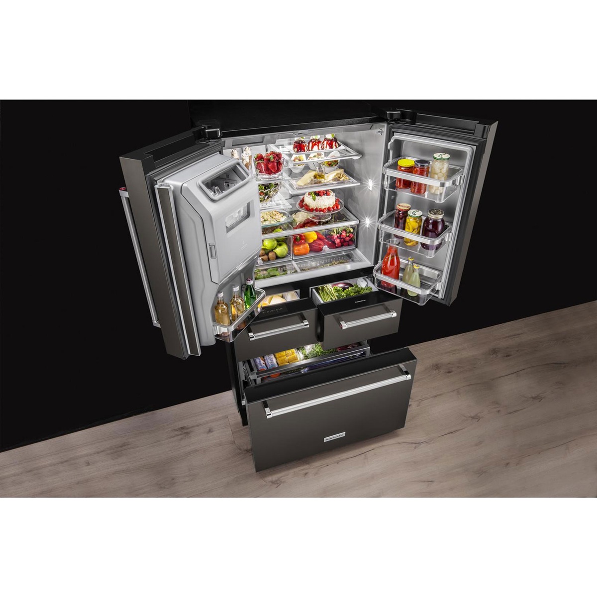 KitchenAid 5-door French door refrigerator shown open with illuminated shelves, door bins, and multiple pull-out drawers filled with food