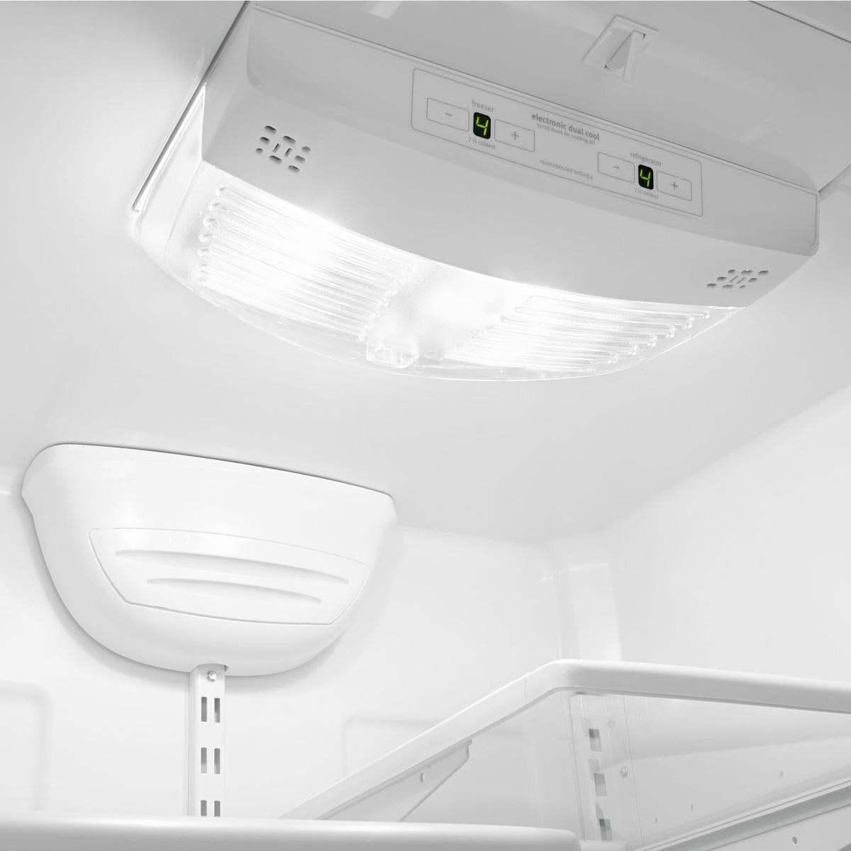 Interior top control panel with digital temperature readouts and plus-minus buttons under a bright interior light cover