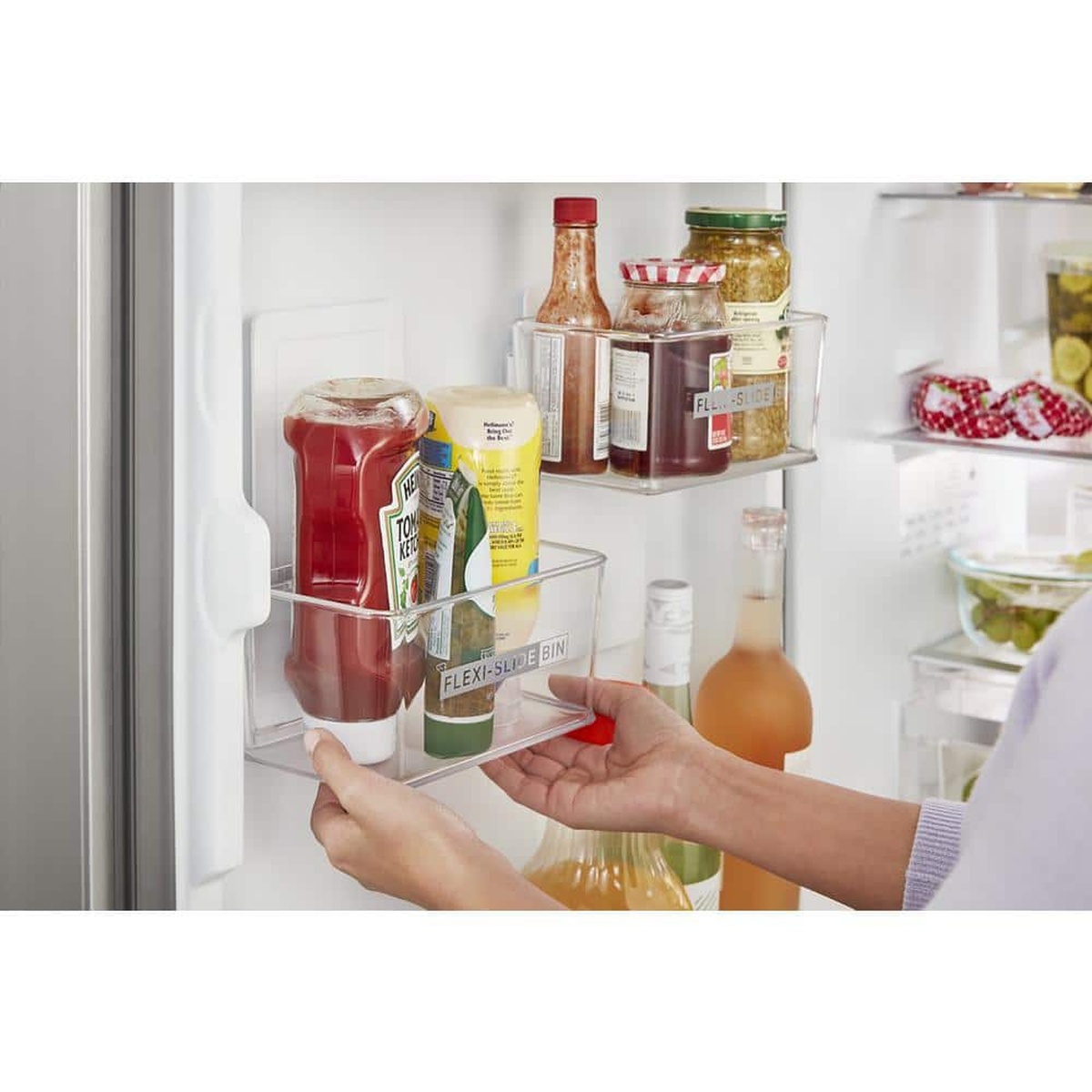 Close-up of the refrigerator door storage showing a Flexi-Slide bin being adjusted while holding bottles and condiments