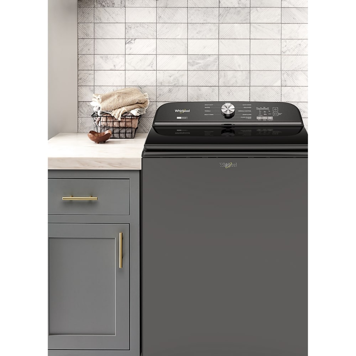 Volcano Black Whirlpool top load washer installed in a laundry room next to cabinetry and a countertop