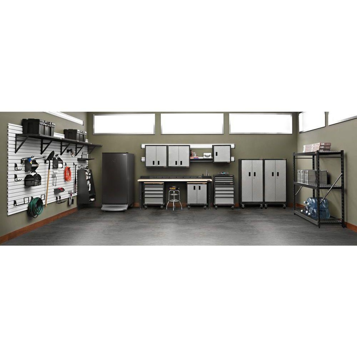 Organized garage scene with Gladiator cabinets, wall storage, and the matching upright freezer